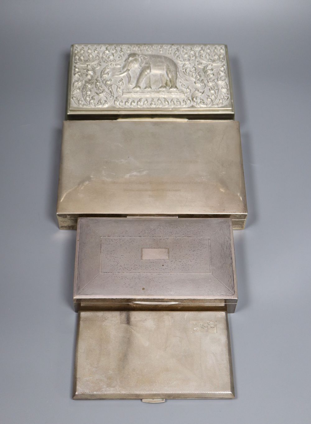 Two silver cigarette boxes, a silver cigarette case and Thai white metal cigarette box, largest 18.7cm.